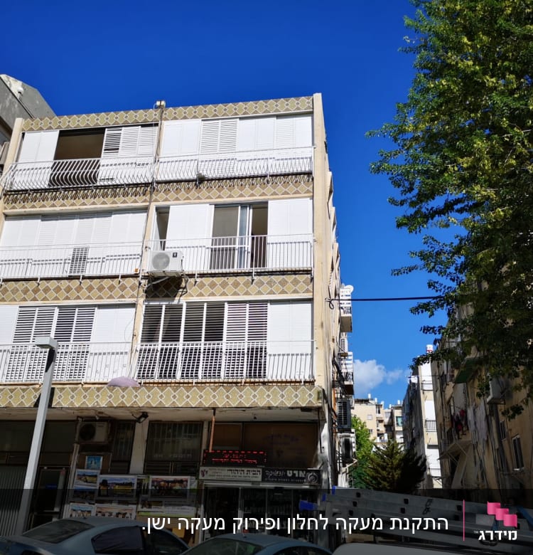 בניין עם תריסים לבנים ומעקות ברזל